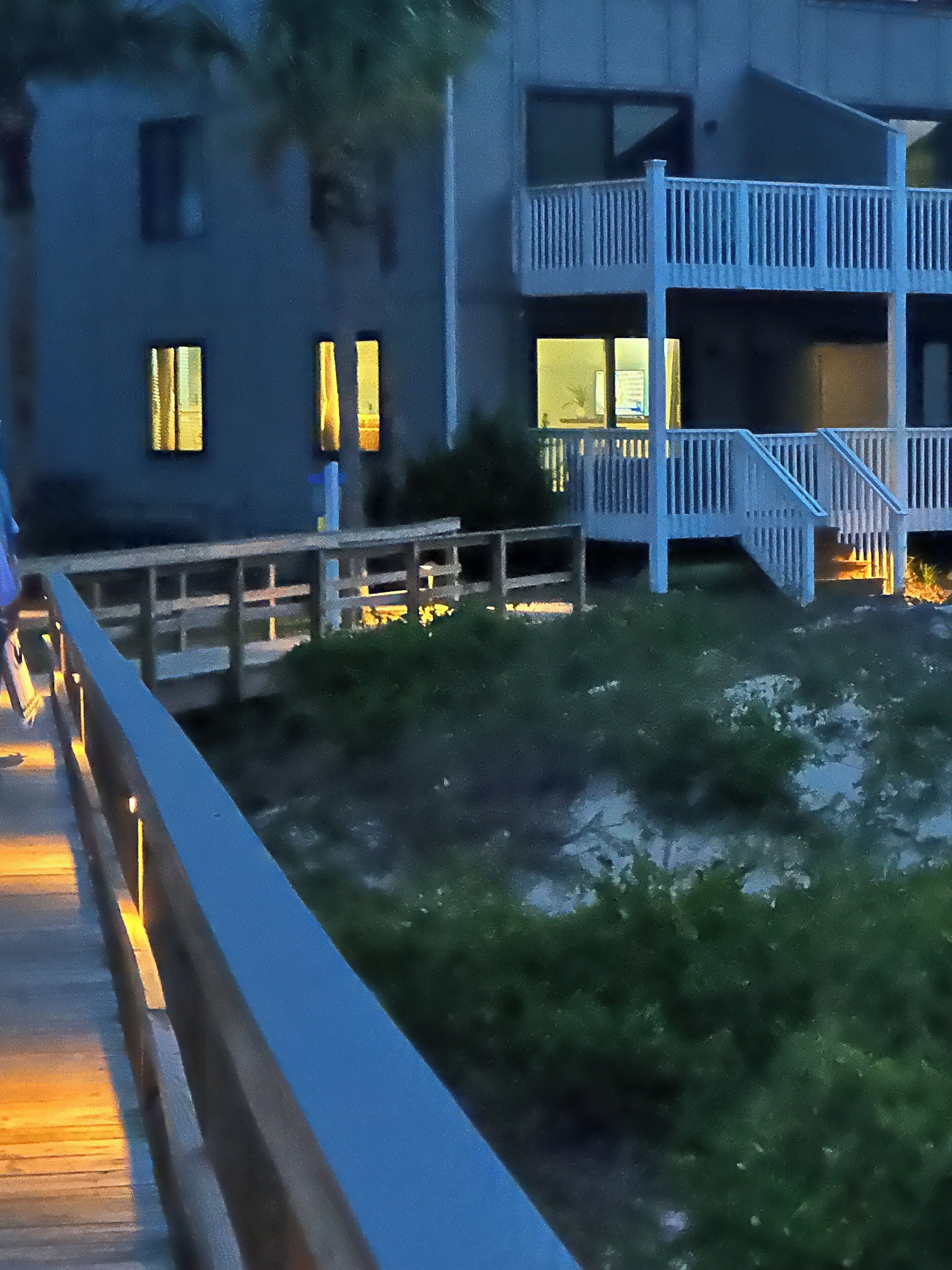 A building with multiple floors, a balcony, and a staircase.