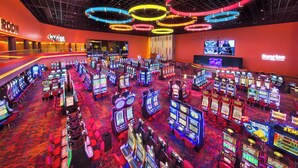 A casino with multiple gaming machines, a stage area, and a large screen displaying a game. - Large Private Villa with Pool, Sauna, Billiards, Minutes from the Beach (Dania Beach)