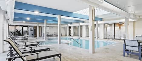 Zona de piscina con bancos, un jacuzzi y un área de estar techada.