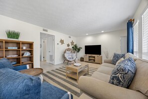 Ein modernes Wohnzimmer mit Sofa, Couchtisch und TV-Schrank.