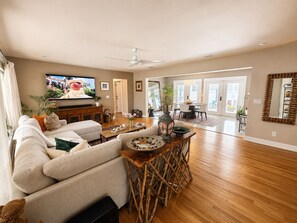 Ein großzügiges Wohnzimmer mit einer Couch, einem Couchtisch und einem Fernseher.