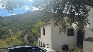 A building with a white facade, black window frames, and a number '26' on the wall. - Andalusian Villa - Family Gatherings, Group Retreats & Nature Escapes (Iznajar)