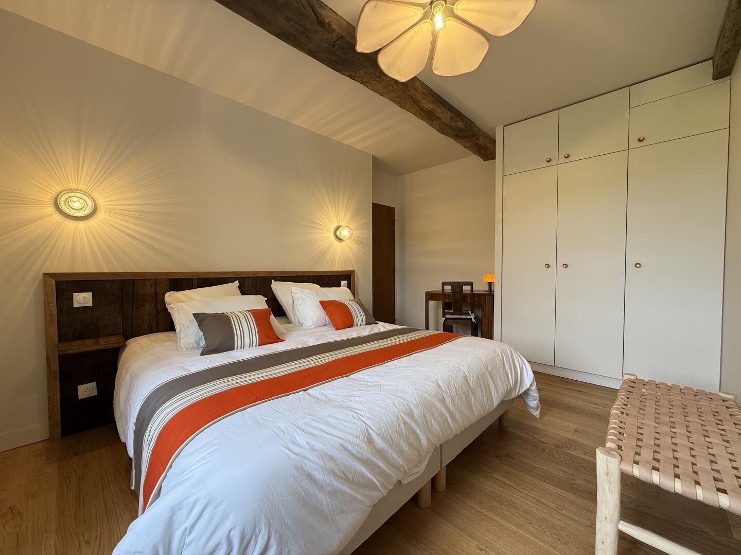 Ein Schlafzimmer mit einem großen Bett, Nachttischen, einem Schreibtisch und einem Kleiderschrank.