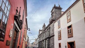 A narrow street lined with historic buildings, featuring ornate facades and traditional architecture. - Carine Laguna (San Cristobal de La Laguna)