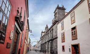 A narrow street lined with historic buildings, featuring ornate facades and traditional architecture. - Carine Laguna (San Cristobal de La Laguna)