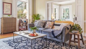 A living room with a sofa, coffee table, and a bookshelf. - Two Beautiful Apartments- Ideal for Groups! (Portland)