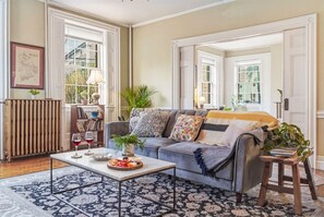 A living room with a sofa, coffee table, and a bookshelf. - Two Beautiful Apartments- Ideal for Groups! (Portland)