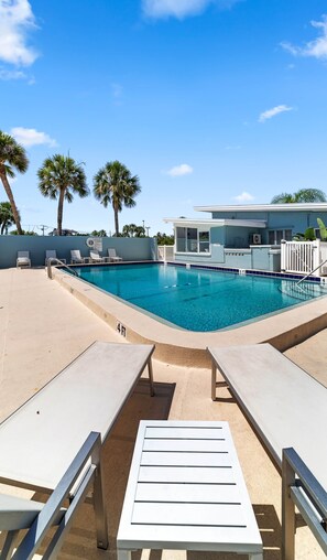 A swimming pool with lounge chairs and a building in the background. - Ivory & Ocean •walk to Lido beach •private patio (Sarasota)