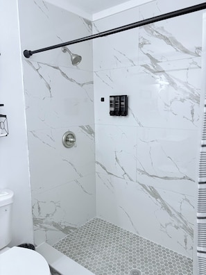 Een douche, handdoeken, zeep, toiletpapier