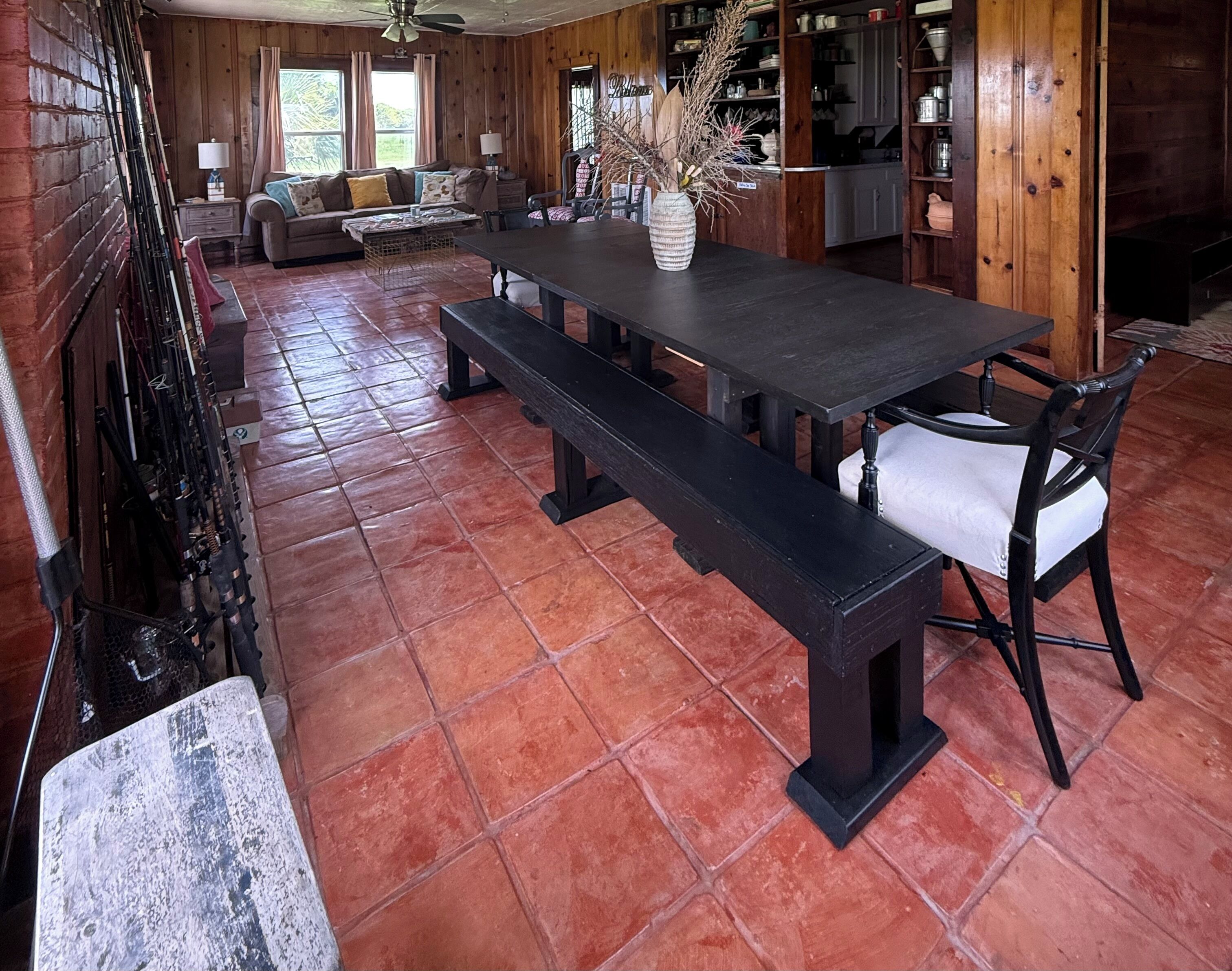 Un intérieur en bois comprenant une table à manger, des bancs, un canapé et un coin cuisine.