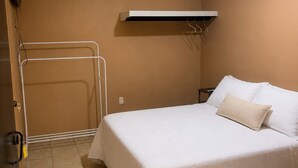A hotel room with a bed, a towel rack, a heater, and a wall-mounted air conditioning unit. - Your stay 5 min from Santa Ana Cathedral (Santa Ana)