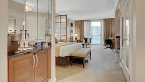 Hotelkamer met een groot bed, een bureau, een stoel, een spiegel en uitzicht op de stad.
