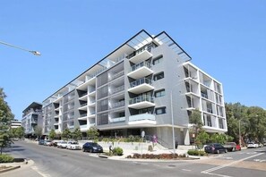 A modern multi-story building with balconies, a parking area, and a clear sky. - ROSE9 - Sunlit Rosebery Stay | Balcony & Easy Airport Access (Sydney)