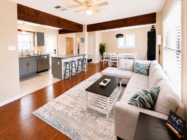 A modern living room with a sofa, coffee table, and a rug.
