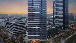 Et moderne hotel med en buet facade, flere etager og en markant indgang.