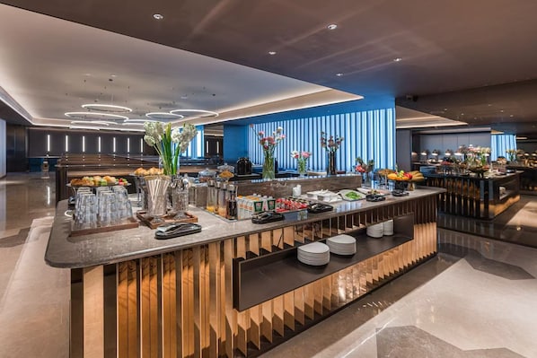 A modern hotel lobby with a reception desk, a buffet area, and a blue-striped wall. - Crystal Orange Hotel UESTC Chengdu West (Chengdu)