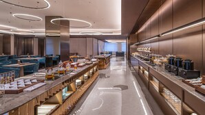 A modern hotel lobby with a long reception desk, seating area, and a buffet. - Orange Crystal Hotel Chengdu South Railway Station (Chengdu)