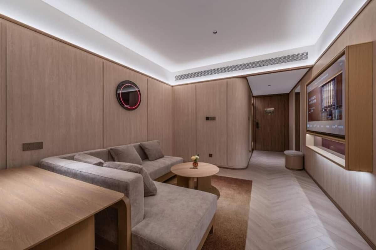 A modern interior with a sofa, a small round table, and a wall-mounted circular light fixture.