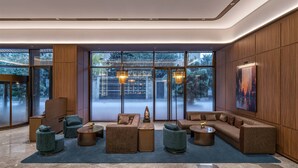 A modern lobby with a sectional sofa, armchairs, and a coffee table. - Orange Crystal Hotel Chengdu South Railway Station (Chengdu)