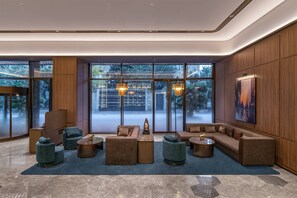 A modern lobby with a sectional sofa, armchairs, and a coffee table. - Orange Crystal Hotel Chengdu South Railway Station (Chengdu)