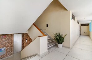 A modern hotel interior with a staircase, a potted plant, and a tiled floor. - Rodadero Sol & Mar (Gaira)