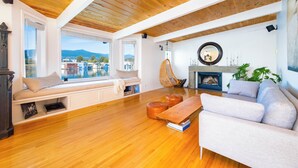 A cozy living room with a wooden ceiling, a sofa, a bench, and a fireplace.