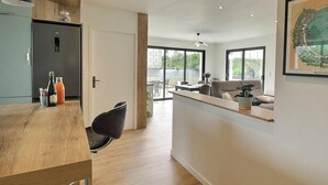 Een moderne keuken met een houten aanrecht, een zwarte stoel en een koelkast.