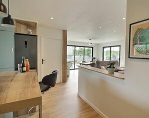 A modern kitchen with a wooden countertop, a black chair, and a refrigerator. - Ker Alran - PLENEUF VAL ANDRE (PLENEUF VAL ANDRE)
