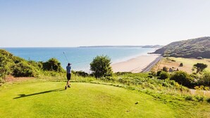Een golfbaan met uitzicht op het strand en de oceaan.
