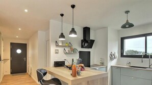 Een moderne keuken met een houten eiland, hanglampen en een groot raam.