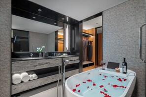 Klassieke suite | Badkamer | Een aparte badkuip en douche, een haardroger, pantoffels, handdoeken