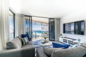 Ein modernes Wohnzimmer mit Sofa, Couchtisch und Fernseher.