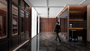 A modern hallway with a polished marble floor, wooden paneling, and a digital elevator display. - IntercityHotel Taikoo Li Chunxi Rd (Chengdu)