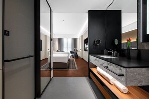 A modern hotel room with a bed, a desk, a bathroom with a sink and mirror, and a view of the city. - IntercityHotel Chengdu TICC (Chengdu)