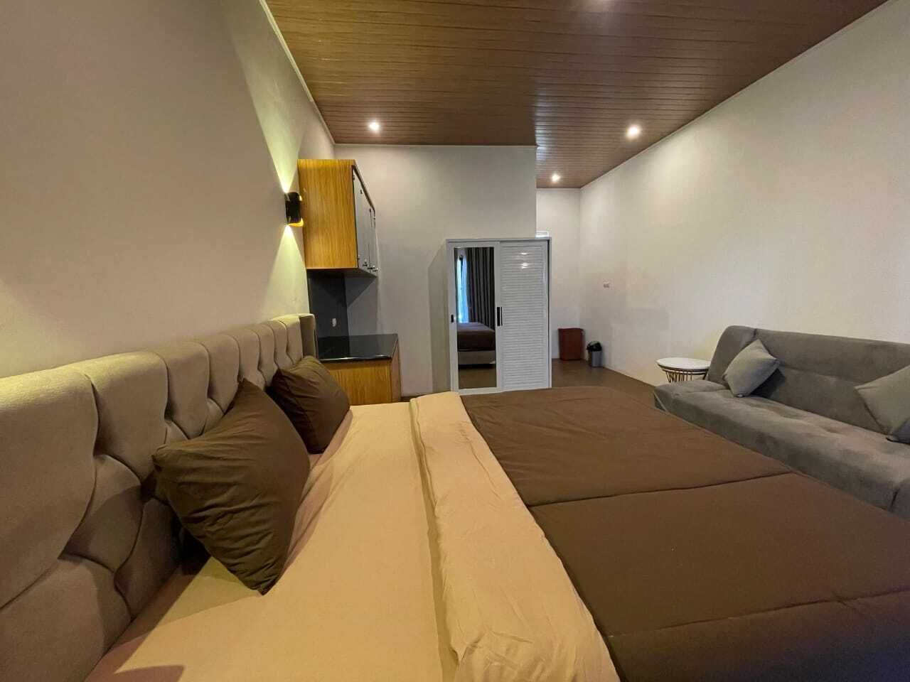 Une chambre moderne avec un lit, un canapé, une armoire et une petite table.
