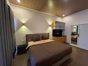 Een slaapkamer met een bed, een televisie, een kledingkast en een spiegel.