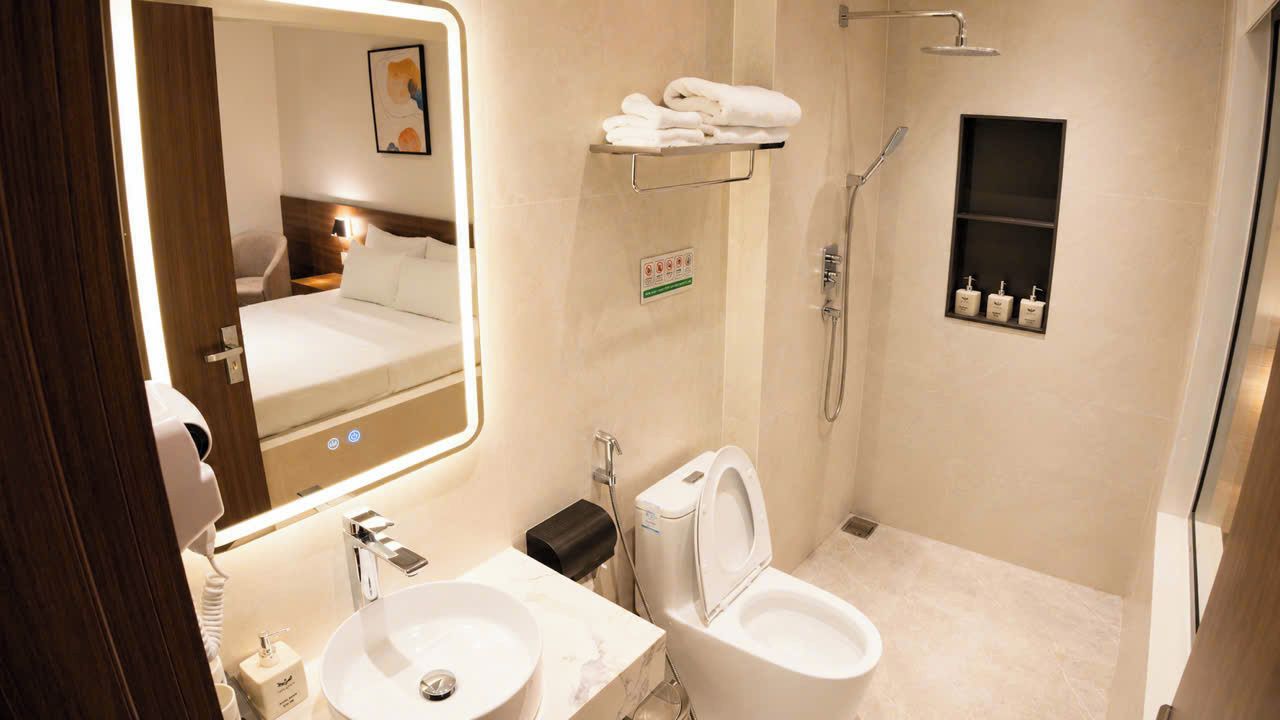 Ein modernes Badezimmer mit großem Spiegel, Waschbecken, Toilette und Dusche.