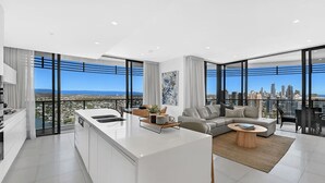 A modern apartment with a kitchen, living area, and large windows offering city views. - Ocean and City at Oracle Level 32 (Gold Coast City)