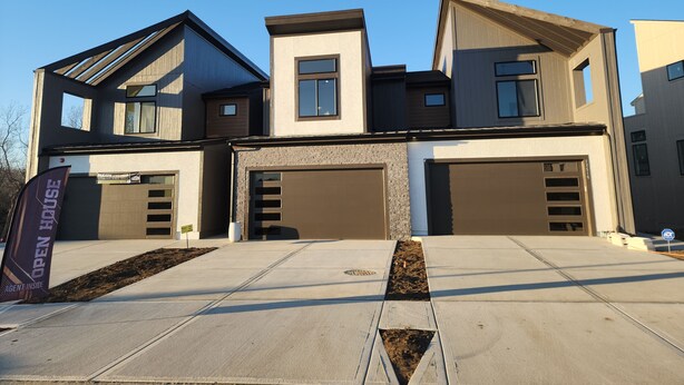 A modern two-story house with a garage, a driveway, and a landscaped front yard. - Lenexa Executive Getaway (Lenexa)