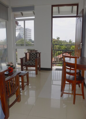A spacious balcony with a view of the cityscape, furnished with wooden chairs and a table. - The Kumatha Residence,Second Floor Studio apartment, 5 minutes walk to the beach (Negombo)