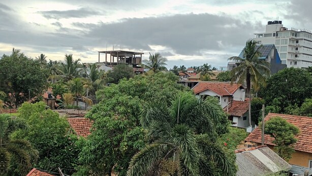 A residential area with various houses, some with red-tiled roofs, surrounded by greenery and palm trees. - The Kumatha Residence,Second Floor Studio apartment, 5 minutes walk to the beach (Negombo)