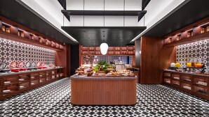 Una cocina moderna con una isla central, armarios de madera y suelo estampado.