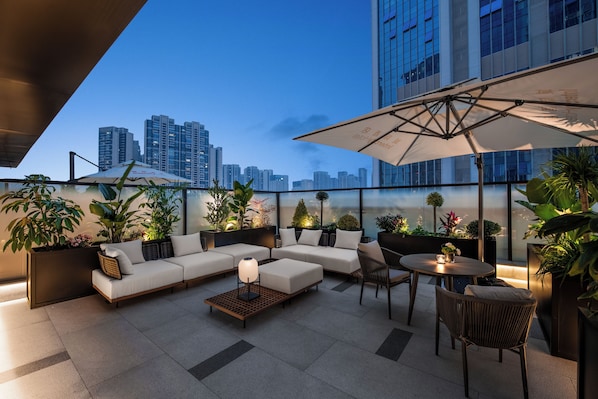 A rooftop lounge with a sofa set, a table with chairs, and potted plants. - IntercityHotel Chengdu Western Expo City Center (Chengdu)