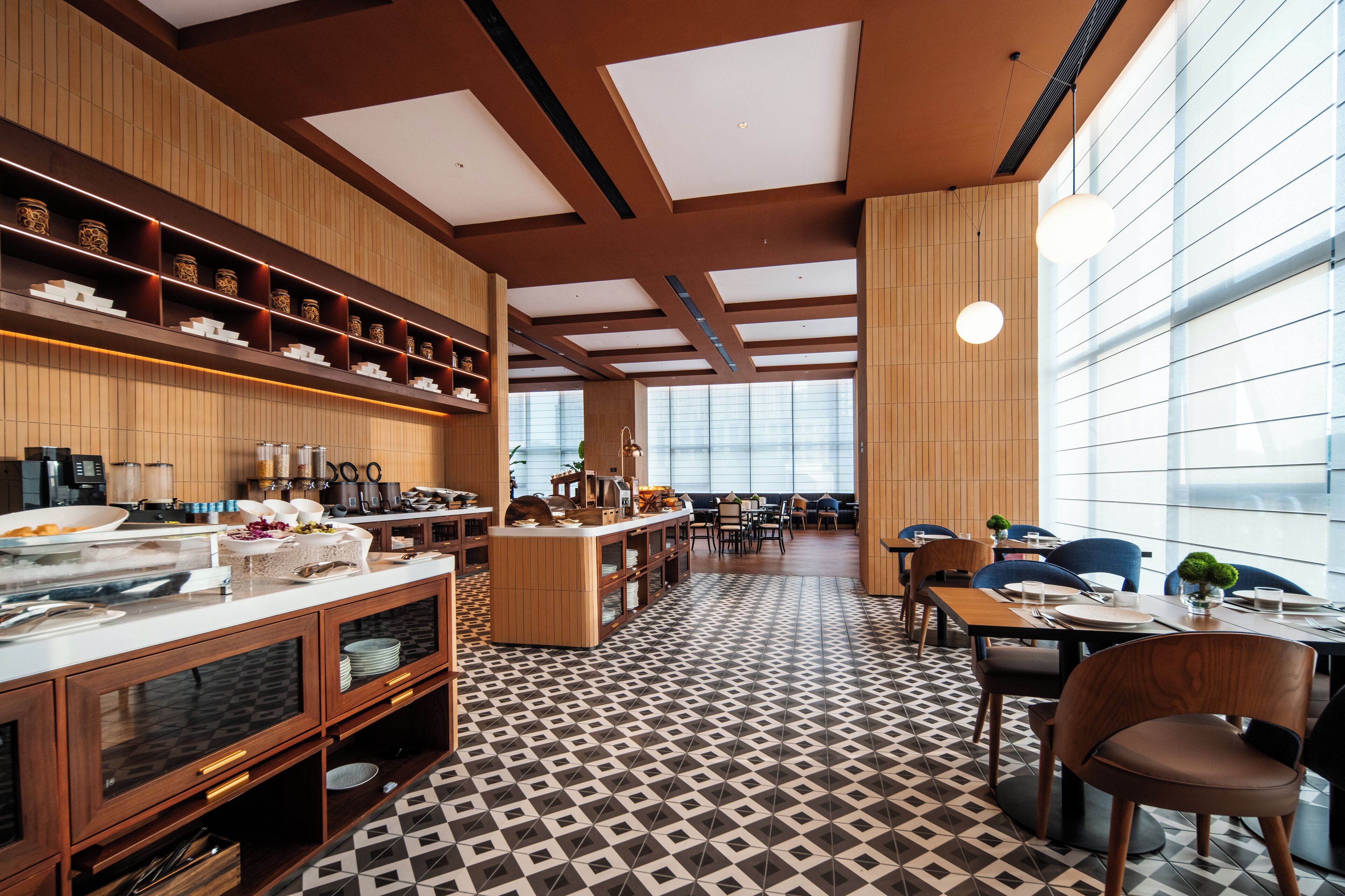 A modern dining area with a central island, wooden paneling, and a patterned floor.