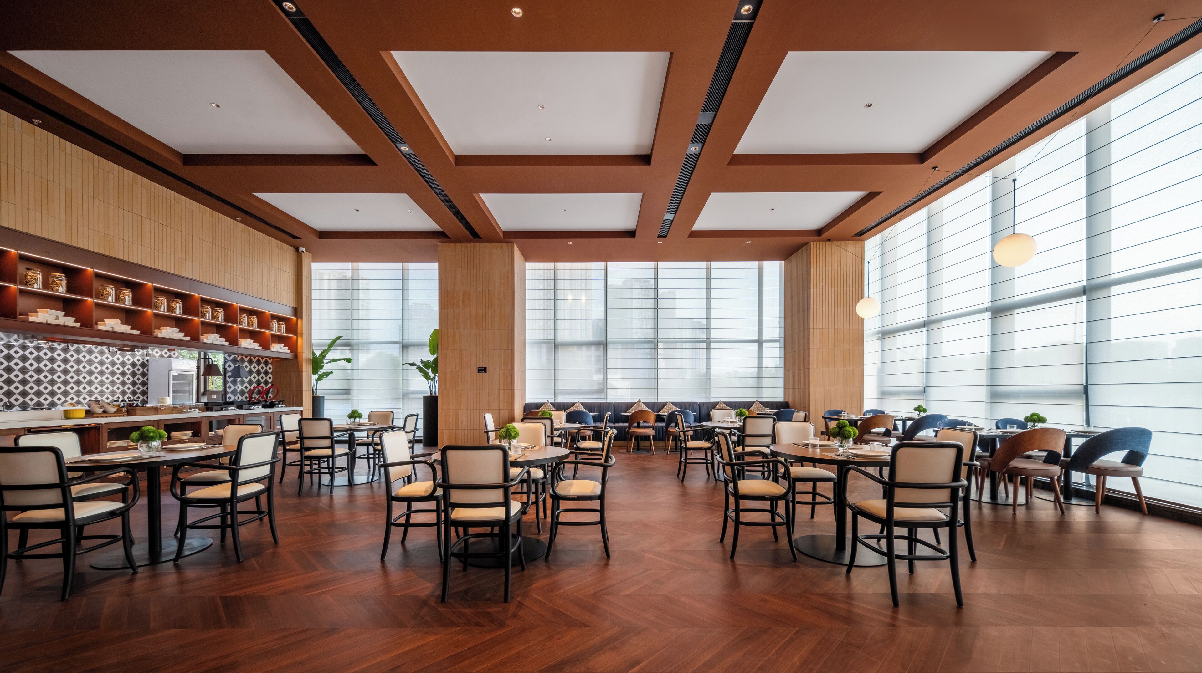 A spacious dining area with high ceilings, large windows, and a variety of seating arrangements.