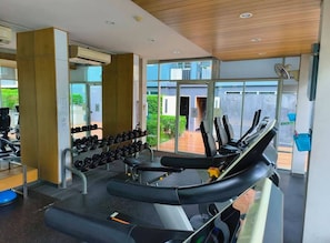 Ein Fitnessstudio mit Laufbändern, Kurzhanteln und Trainingsgeräten.