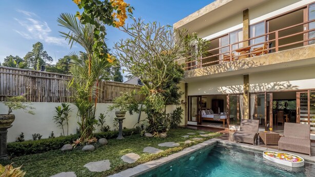 A two-story building with a swimming pool, outdoor furniture, and a garden area. - Villa Ciconia Ubud (Ubud)