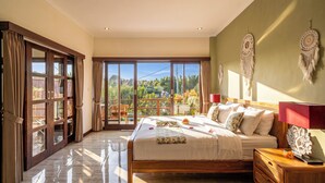 A bedroom with a large bed, a nightstand, a wall-mounted lamp, and a view through a sliding glass door. - Villa Ciconia Ubud (Ubud)