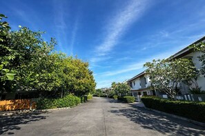 A residential street with houses, greenery, and a clear sky. - Chalong Miracle Lakeview 4021 (Chalong)