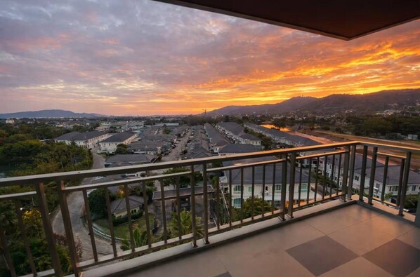 A balcony with a view of a residential area during sunset. - Chalong Miracle Lakeview 4021 (Chalong)